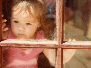 Little Tamara looks thru window pane, photo by her father Mark Boyens